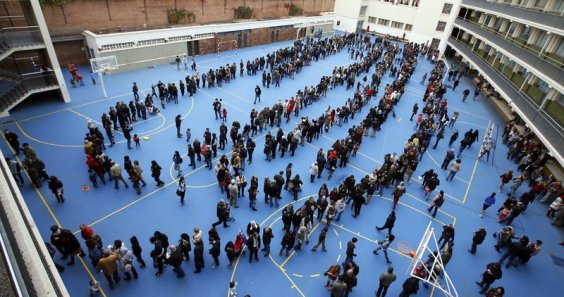 People queue at a polling station to cast their ballots in a symbolic independence vote in Barcelona